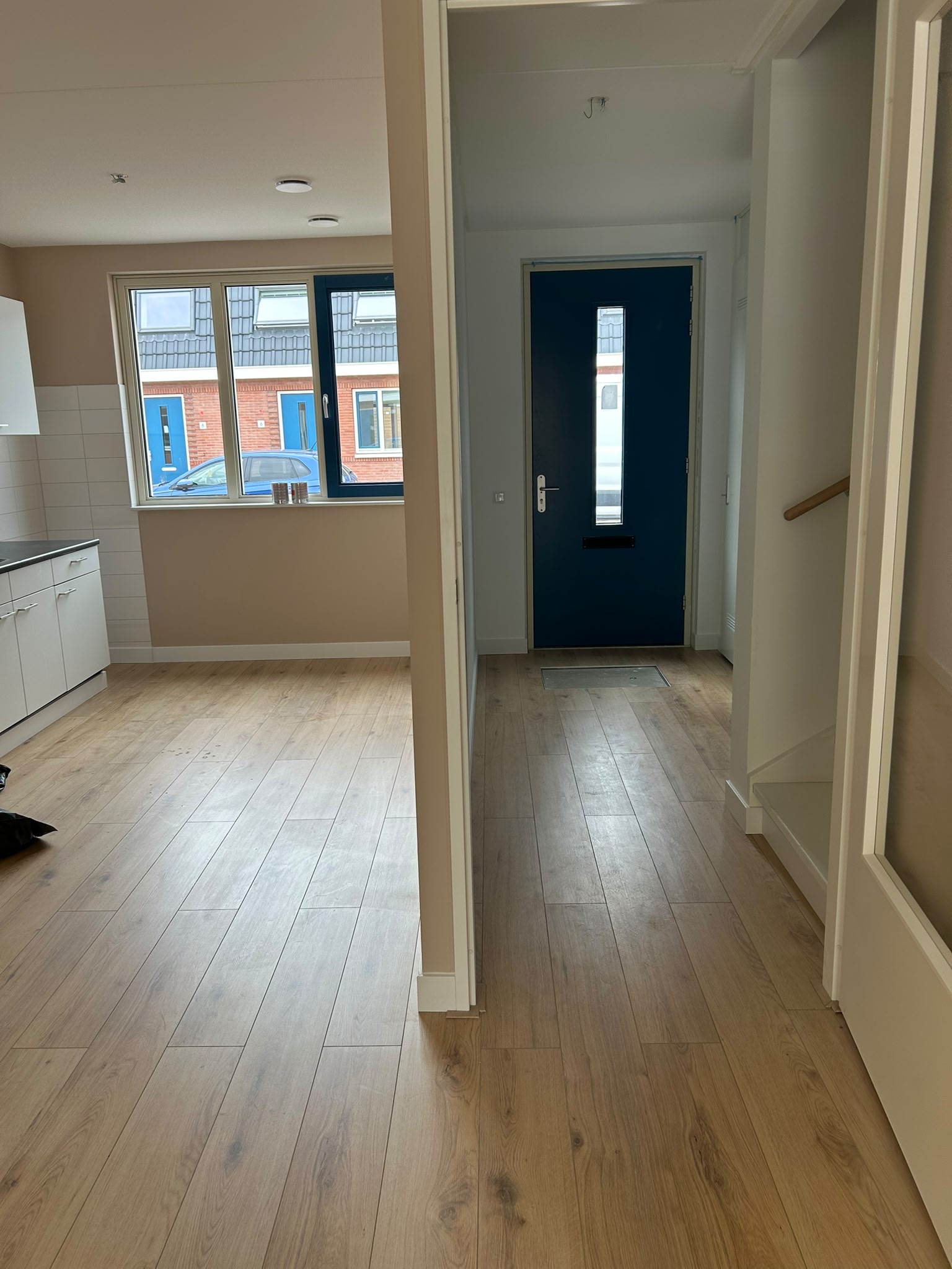 Interieur met ramen, trapzone en donkere voordeur