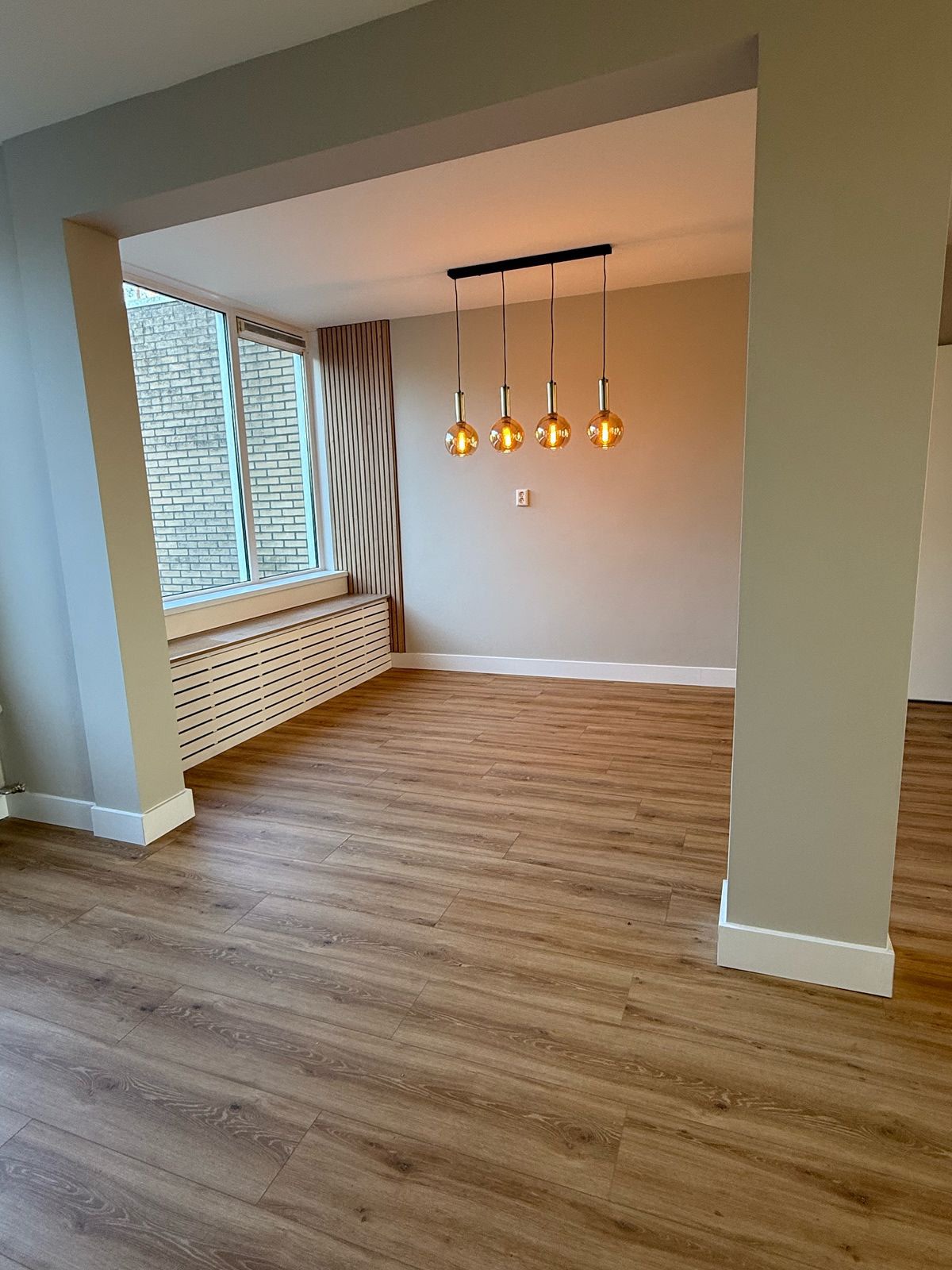 Interieur met houtvloer, schilderwerk en hanglampen