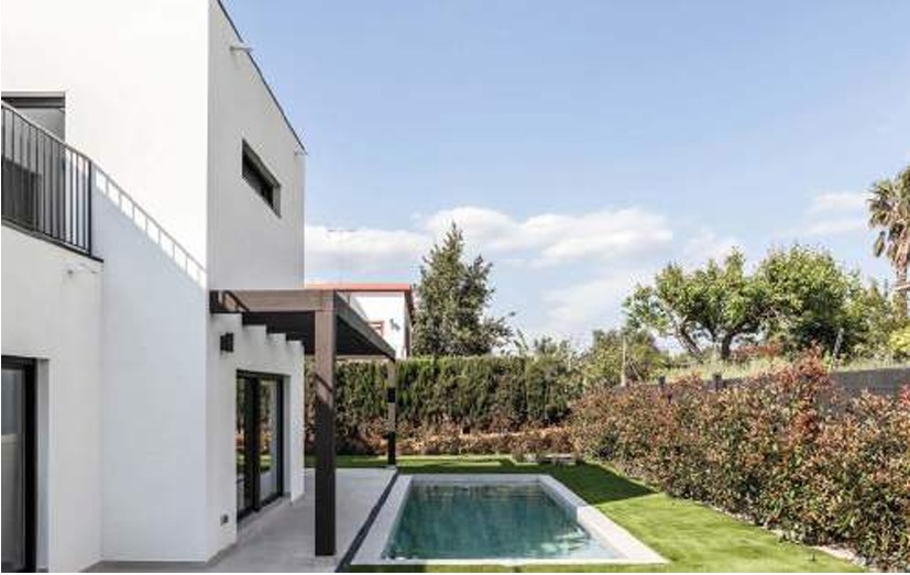 Witte gevel met zwembad, pergola en tuin