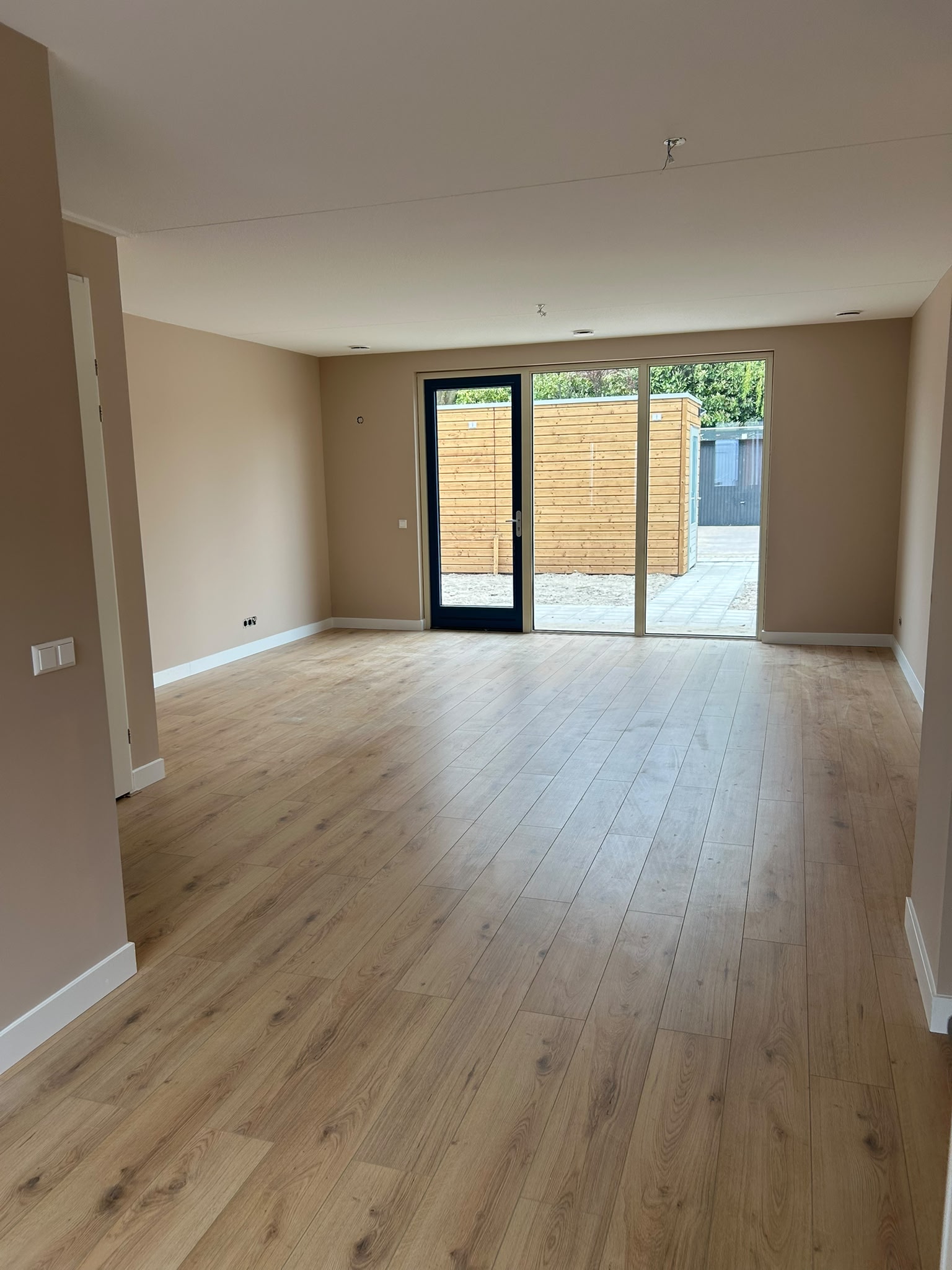 Lege woonkamer met openslaande deuren naar de tuin